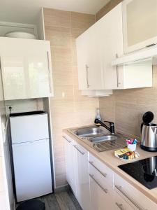 a kitchen with a sink and a white refrigerator at Palm Paradise, by Welcome to Cannes in Cannes