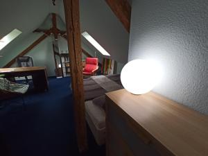 une chambre avec un lit et une lampe sur un comptoir dans l'établissement Zwischen Bauhaus und Park Georgium, à Dessau
