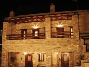 an old stone building with windows at night at Giataki in Karistos