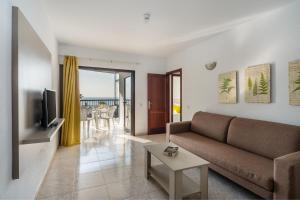 - un salon avec un canapé et une télévision dans l'établissement RT-Apartamentos Guinea, à Playa del Ingles