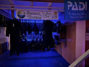 a room with a blue lighted walkway with clothes on display at Shamar Guesthouse & Dive in Maamigili