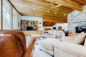 a living room with leather furniture and a stone fireplace at The Clymer House in Teton Village