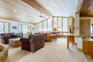 a living room with couches and a table and windows at The Clymer House in Teton Village