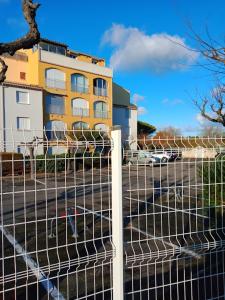 a fence in front of a building with a building at Studio Cap d'Agde le Môle in Cap d'Agde