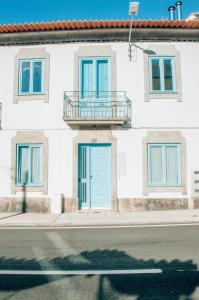 a white house with a blue door on a street at Xicotina in Moledo