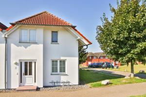 a white house with a red roof at Ferienapartment-ruegen in Neddesitz