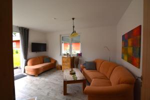 uma sala de estar com dois sofás e uma mesa em Urlaub am Plätlinsee Haus Rike em Wustrow
