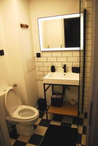 een badkamer met een toilet, een wastafel en een spiegel bij Loft Apartament ULA in Elblag