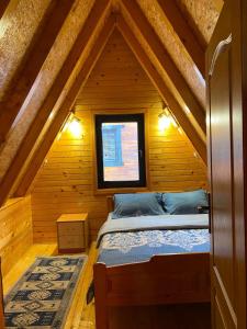 a bedroom with a bed in a wooden attic at Holiday Home Vojinovic in Žabljak
