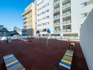 un parco giochi di fronte a un edificio con sedie colorate di Jardin Luxury fjHomefj a Jerez de la Frontera
