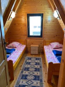 a room with two beds in a log cabin at Holiday Home Vojinovic in Žabljak
