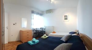 a bedroom with two beds and a dresser in it at Villa Radoš - 4 Sterne, 3 Apartments für maximal 18 Gäste in Supetar