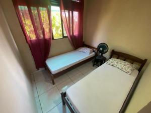 ein kleines Zimmer mit zwei Betten und einem Fenster in der Unterkunft Sibauma Aparts in Pipa