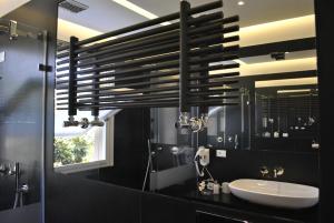 a black bathroom with a sink and a mirror at B&b Mondello Resort in Palermo