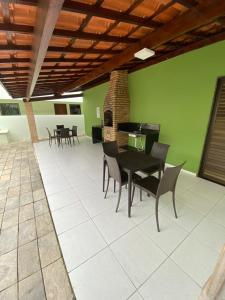 eine Terrasse mit einem Tisch, Stühlen und einem Klavier in der Unterkunft PRAIA RESIDENCE Rua Cajueiro in Ipojuca