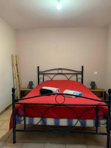 a bed with a red comforter and a red blanket at Les métayers du Filou 2 in Castelnau-de-Montratier