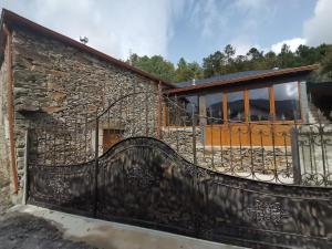 une maison avec un portail et un mur en pierre dans l'établissement Casa do Julien Mountain Experience, à Vila Real