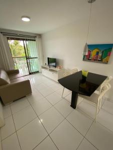 ein Wohnzimmer mit einem schwarzen Tisch und Stühlen in der Unterkunft PRAIA RESIDENCE Rua Cajueiro in Ipojuca
