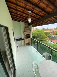 einen Balkon mit einem Kamin sowie einem Tisch und Stühlen in der Unterkunft PRAIA RESIDENCE Rua Cajueiro in Ipojuca