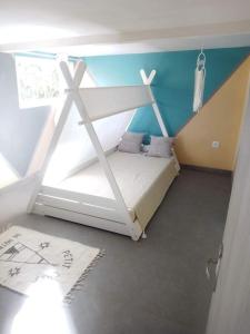 1 dormitorio con 1 cama con una cruz pintada en la pared en Odelil, en Le Guillaume