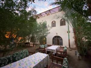 an outdoor patio with tables and chairs in front of a building at Nour El Balad in Luxor