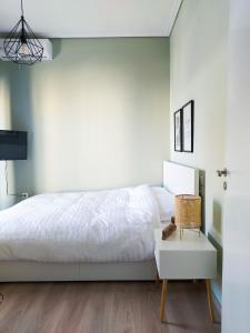 a bedroom with a white bed and a white table at Hygge Home at Trikala in Tríkala