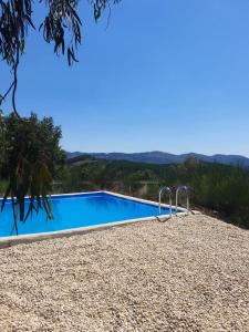 een blauw zwembad met een berg op de achtergrond bij Refúgio do Sobreiro in Cabeceiras de Basto
