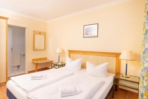 a bedroom with a large white bed with white pillows at Ferienapartment-ruegen in Neddesitz +22 photos