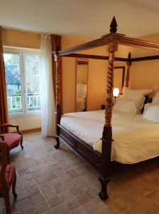 a bedroom with a four poster bed and a window at Hostellerie Les Hauts De Sainte Maure in Sainte-Maure-de-Touraine