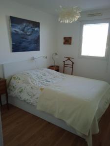 een slaapkamer met een groot wit bed en een raam bij Appartement Cosy Terrasse vue Quai Canal + parking in Sète