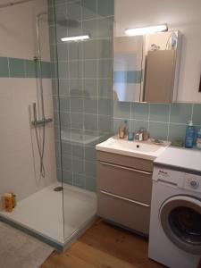 een badkamer met een douche en een wasmachine bij Appartement Cosy Terrasse vue Quai Canal + parking in Sète