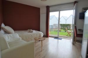 a bedroom with a bed and a sliding glass door at Jardin - à 50m de la plage - Wifi - Parking in Courseulles-sur-Mer