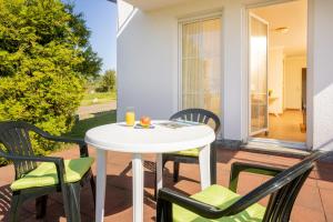 a white table and chairs on a patio at Ferienapartment-ruegen in Neddesitz