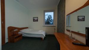 a bedroom with a bed and a desk and a television at Pieprz & Wanilia Noclegi in Murowana Goślina +9 photos