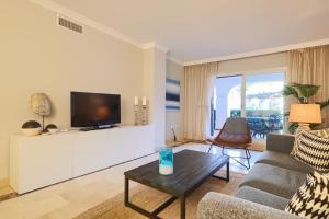 een woonkamer met een bank en een tv bij Beach Side 2 Bedroom apartment in La Gavia San Pedro in Marbella