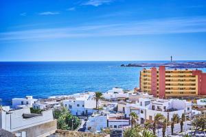 un grupo de edificios blancos y el océano en 2BDR Comfy Apartment with Ocean View, en Porís de Abona