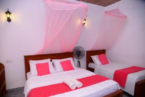 sypialnia z 2 łóżkami z czerwoną i białą pościelą w obiekcie Serene Cottage Ella w mieście Ella