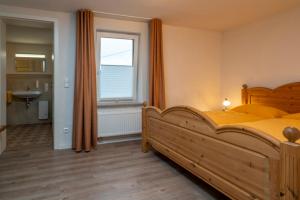ein Schlafzimmer mit einem Holzbett und einem Fenster in der Unterkunft Schusters Haus in Boppard