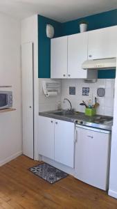 a kitchen with white cabinets and a sink at T2 Coeur d' Argelès-Gazost, tout à pied in Argelès-Gazost
