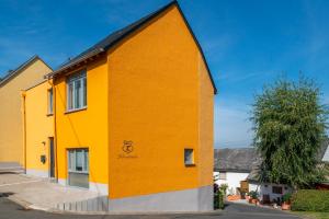 ein gelbes und orangefarbenes Gebäude auf einer Straße in der Unterkunft Schusters Haus in Boppard