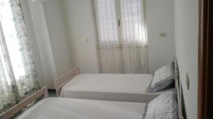 een kleine slaapkamer met 2 bedden en een raam bij La casa di Ester in Lavagna
