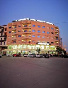 a large building with cars parked in a parking lot at HOTEL BEAUTIFUL in Nador