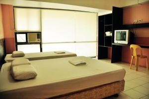 1 dormitorio con 1 cama grande y TV en GV Hotel - Lapu-Lapu City, en Mactan