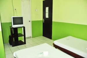 Camera verde e bianca con TV e letto di GV Hotel - Lapu-Lapu City a Mactan