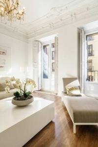 a white living room with a table and a couch at Centro Madrid. Plaza Mayor. Puerta del Sol. Opera. in Madrid