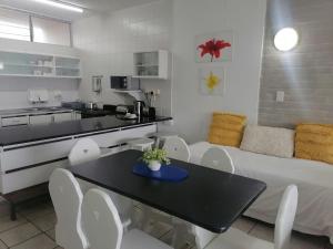 Seagull Beach resort flat number 313 في مارغيت: مطبخ وغرفة معيشة مع طاولة وأريكة