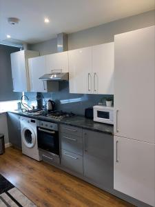 a kitchen with white cabinets and a stove top oven at Showcase Apartments - Kimberley House in Leicester