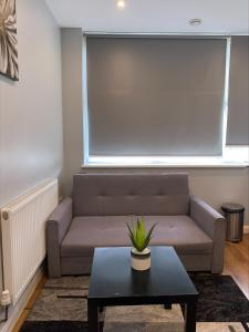 a living room with a couch and a table at Showcase Apartments - Kimberley House in Leicester