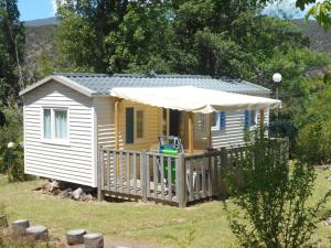 a small yellow house with a porch and an umbrella at Camping Bellevue in Ria