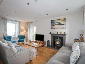 uma sala de estar com dois sofás e uma lareira em Congl Cae em Pwllheli